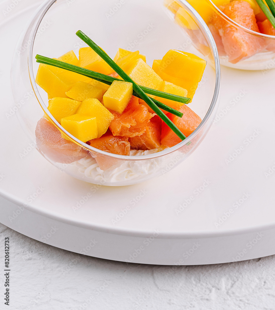 Gourmet salmon and mango tartare in glass bowls Gourmet salmon and mango tartare in glass bowls