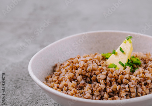 Healthy cooked buckwheat in bowl with butter