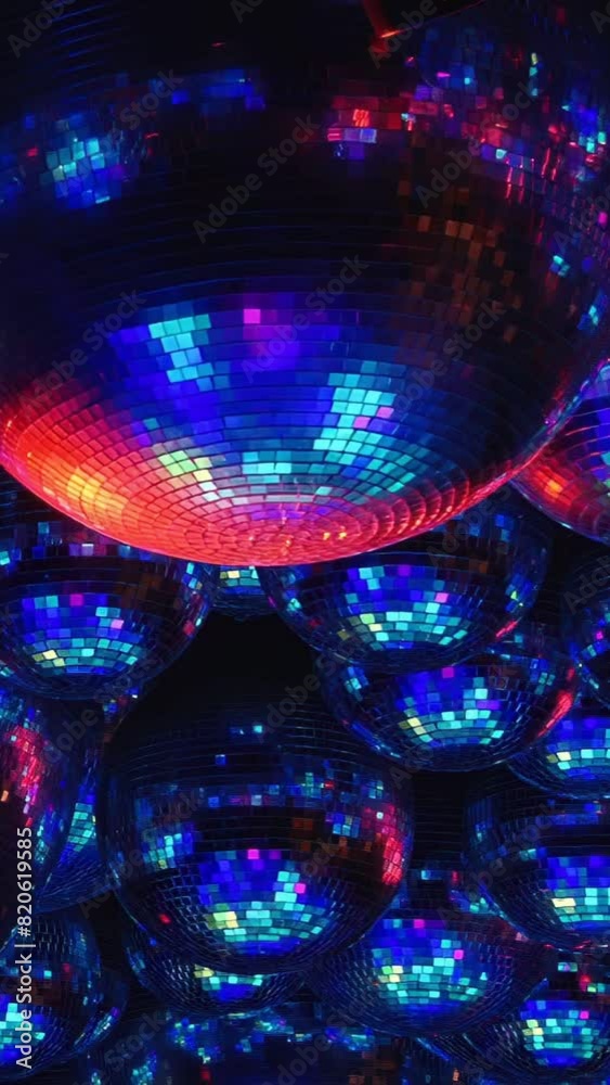 A purple disco ball sits atop a stack of others, all in purple. The shiny spheres add flair and festivity, creating a dazzling setting for celebration and joy