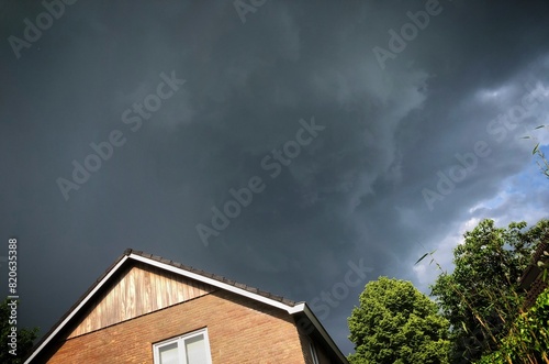 Obraz na płótnie Thunderclouds packing together above a house in the Netherlands. Thunderstorm. Grey clouds. w salonie