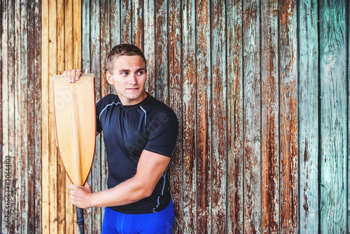 Portrat of young canoeist holding paddle. Concept of canoeing as dynamic and adventurous sport. photo