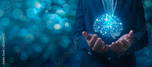 Businessman holding a brain hologram in his hands on a dark blue background with copy space
