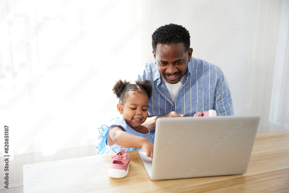 Father doing online shopping and buying more shoes with daughter from laptop computer Father doing online shopping and buying more shoes with daughter from laptop computer