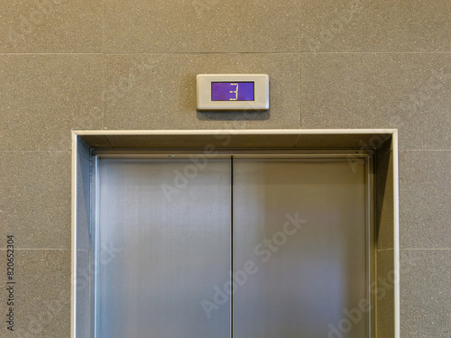 Picture of the top of the elevator door with the number three on the display above the door
