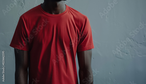 Close-Up Of A Man In A Red T-Shirt Standing Against A Gray Wall, Mocup