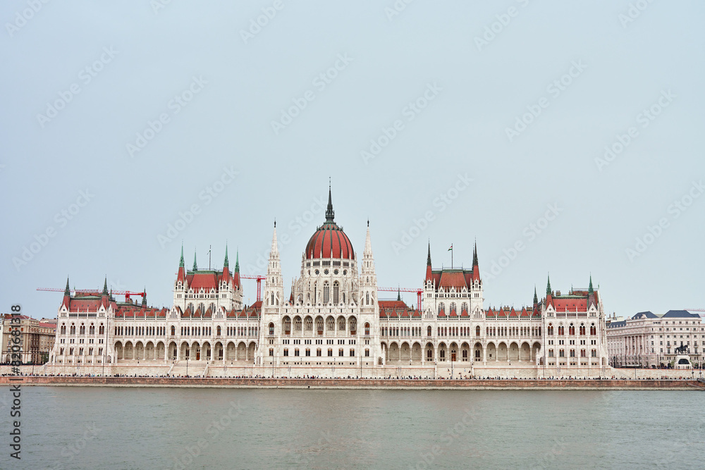 Hungarian Parliament with river Danube, front view. Famous landmark in Budapest. Beautiful architecture with historical building Hungarian Parliament with river Danube, front view. Famous landmark in Budapest. Beautiful architecture with historical building
