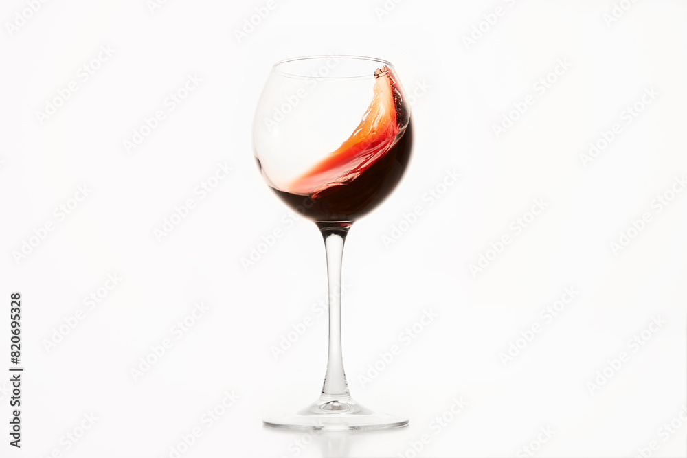 Diagonal wave of red wine, alcohol is in glass on white isolated.