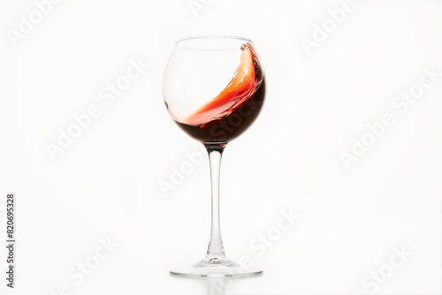 Diagonal wave of red wine, alcohol is in glass on white isolated.