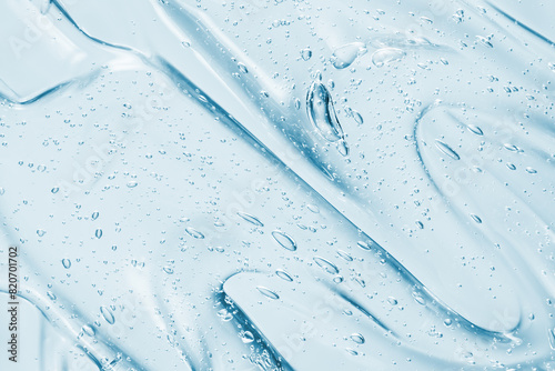 Gel serum texture. Blue liquid skincare background. Transparent beauty product with bubbles closeup