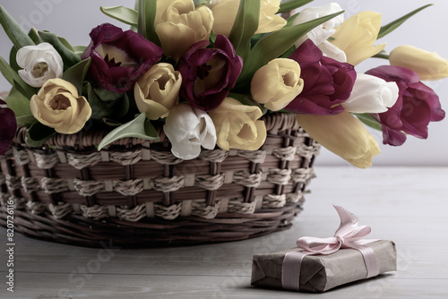 A close-up of a basket with colorful blooming tulips. Holiday card. Copyspace.