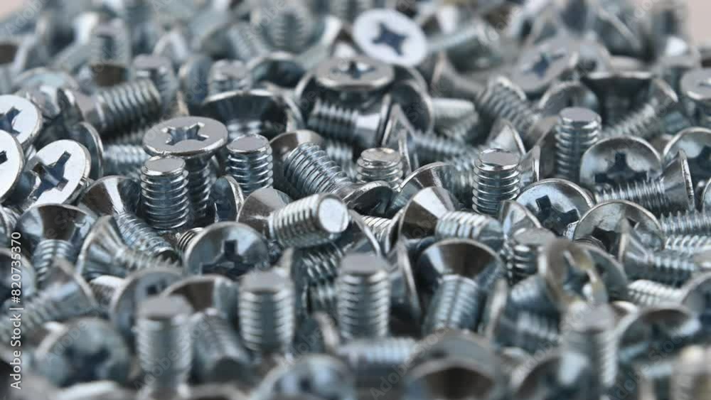 Metric countersunk bolts M6 x 10mm. Movement with rotation. Close-up, side view, small depth of field. Metric countersunk bolts M6 x 10mm. Movement with rotation. Close-up, side view, small depth of field.