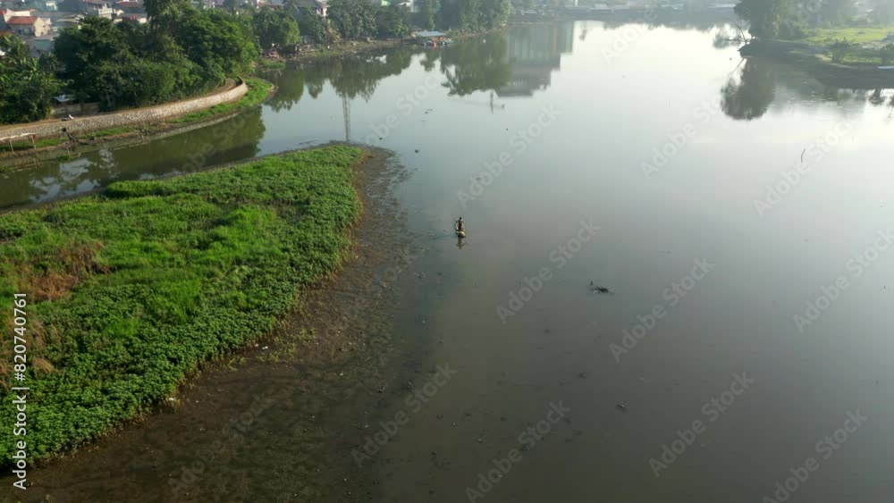 People on the boat in the middle of a lake ; people doing work on country side People on the boat in the middle of a lake ; people doing work on country side