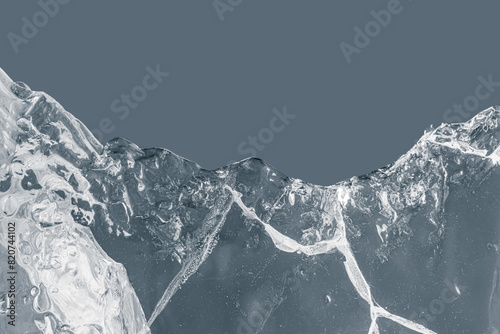Pure transparent crushed ice piece with cracks on a grey background.