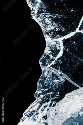 Pure transparent crushed ice piece with cracks on a black background.