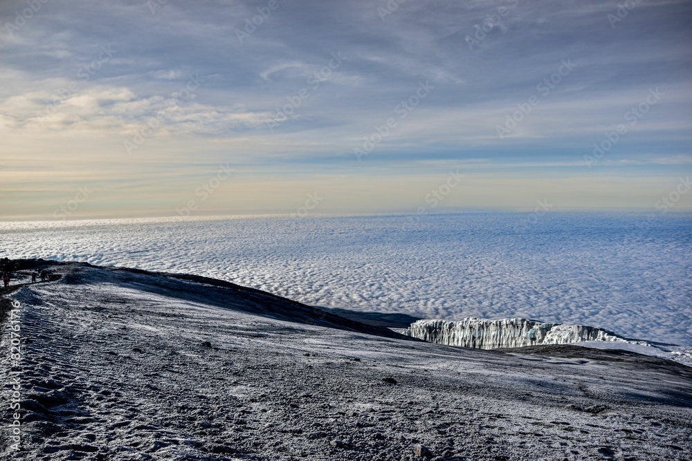 Large, icy glacier on the background of fluffy white clouds Large, icy glacier on the background of fluffy white clouds