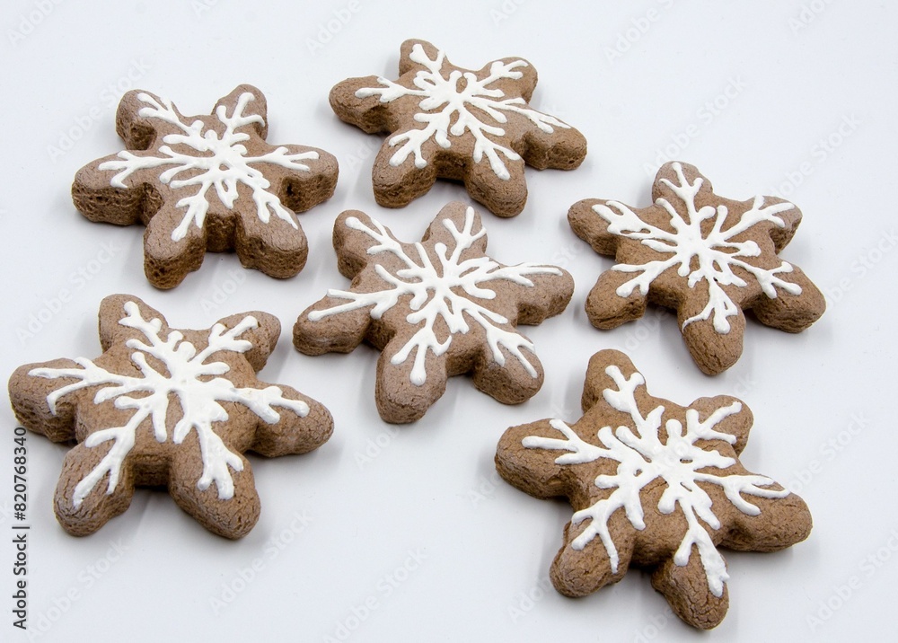 Delicious array of gingerbread snowflake cookies arranged on a neat white surface Delicious array of gingerbread snowflake cookies arranged on a neat white surface