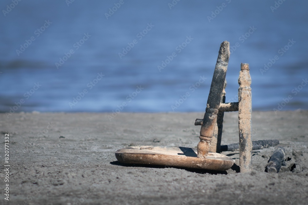 two sticks sticking out of the sand near water and rocks two sticks sticking out of the sand near water and rocks