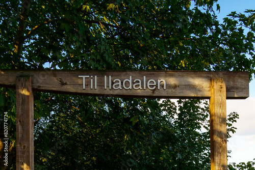 Wood sign maked Til Iladalen on it - Hike to see waterfall on the Ilabekken river by the city of Trondheim, Norway photo