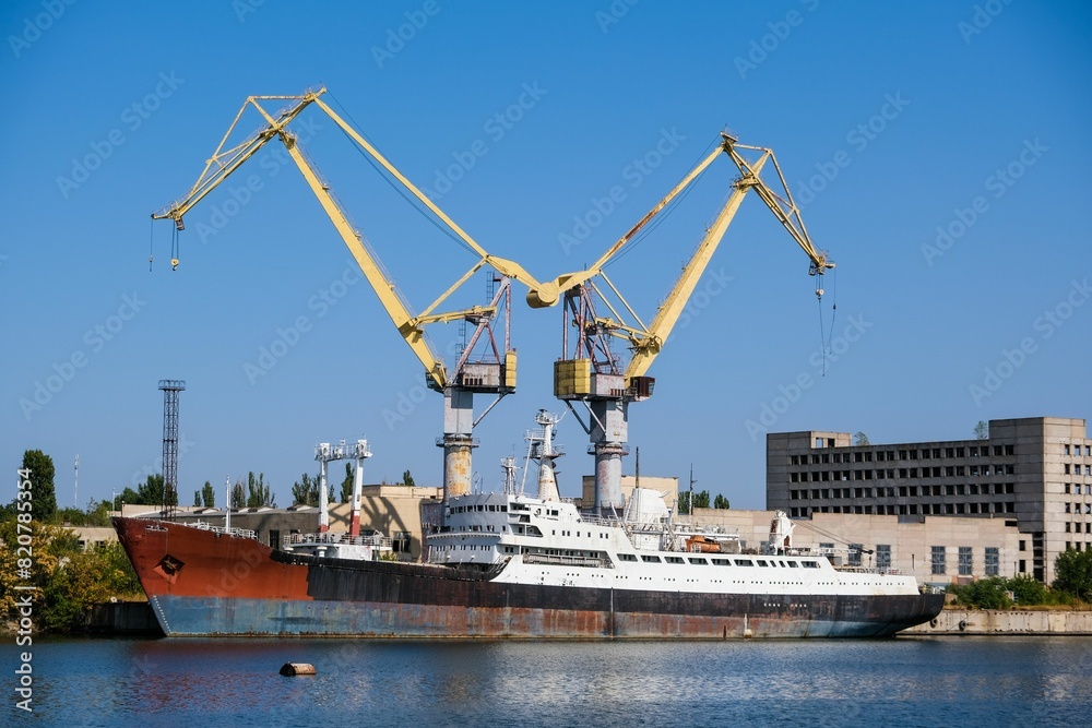 Harbor cranes and a ship under repair at the berth Harbor cranes and a ship under repair at the berth