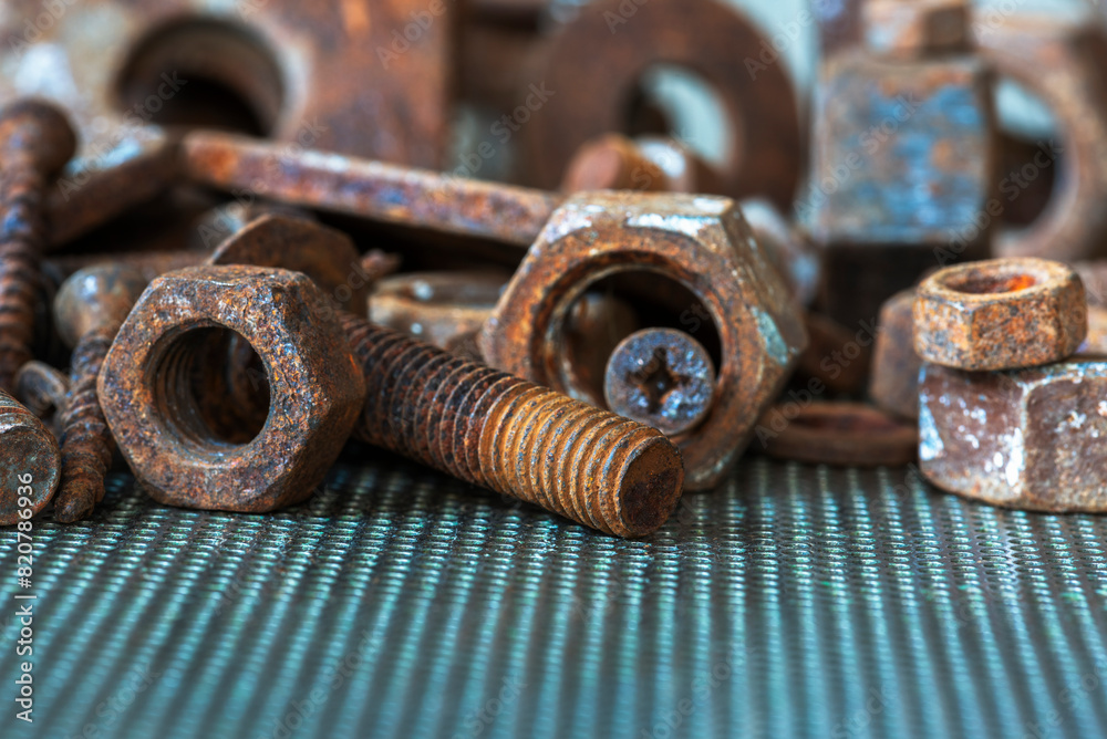 Rusted component, threaded bolt and nut on metal workshop table