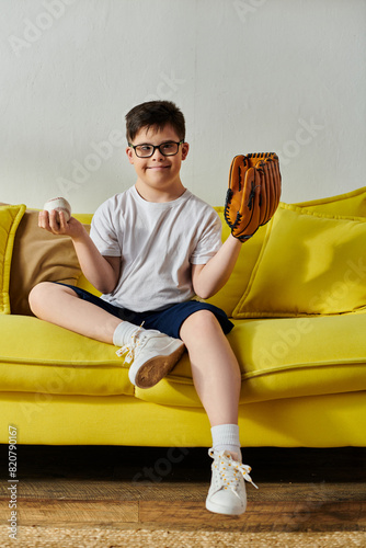 Photography Adorable boy with Down syndrome sitting on couch with baseball glove