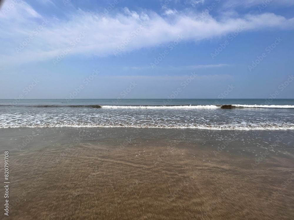 Tranquil ocean with white-crested waves lapping against the shoreline Tranquil ocean with white-crested waves lapping against the shoreline