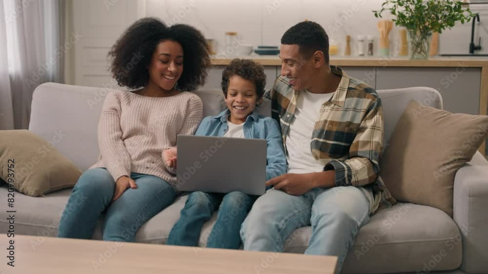 Happy African American family using modern laptop. Mother mom woman female dad father man male help little boy child kid son study learning online education notebook homework talk discuss indoors home Happy African American family using modern laptop. Mother mom woman female dad father man male help little boy child kid son study learning online education notebook homework talk discuss indoors home