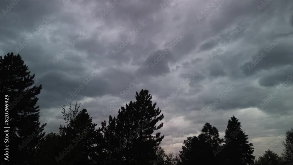 Time lapse of gray cloudscapes above trees at sunset Time lapse of gray cloudscapes above trees at sunset