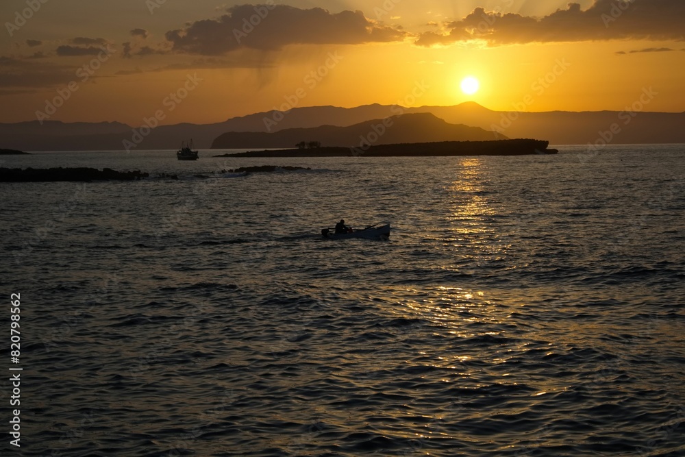 Idyllic landscape of a tranquil body sea against an orange sky at sunset Idyllic landscape of a tranquil body sea against an orange sky at sunset
