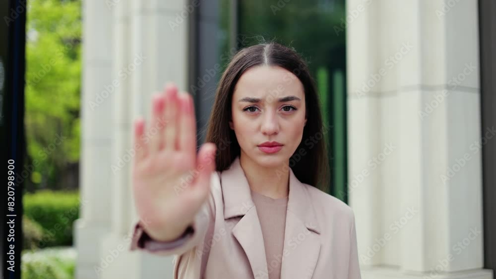 Angry female employer of enterprise company putting palm towards camera and saying no to gender discrimination at work. Progressive feminist setting limits and not tolerating harmful stereotypes. Angry female employer of enterprise company putting palm towards camera and saying no to gender discrimination at work. Progressive feminist setting limits and not tolerating harmful stereotypes.