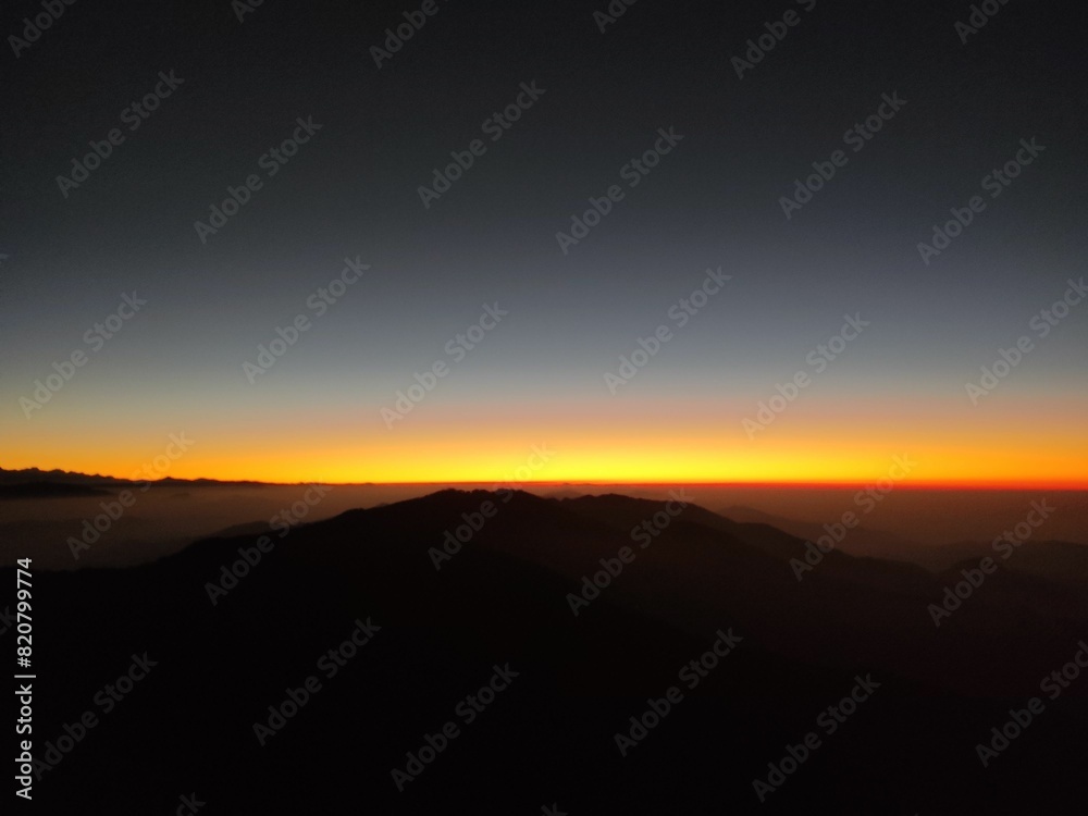 Obraz premium Breathtaking image of a majestic mountain silhouetted against a vibrant sunset sky