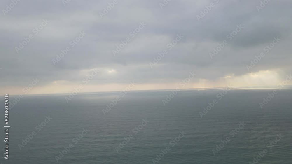 Drone time-lapse view over sea waves covering a coastline on a cloudy day Drone time-lapse view over sea waves covering a coastline on a cloudy day