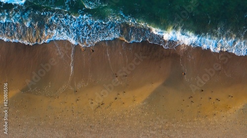 Drone shot: Empty sandy shore, golden sunlight. © Grzegorz