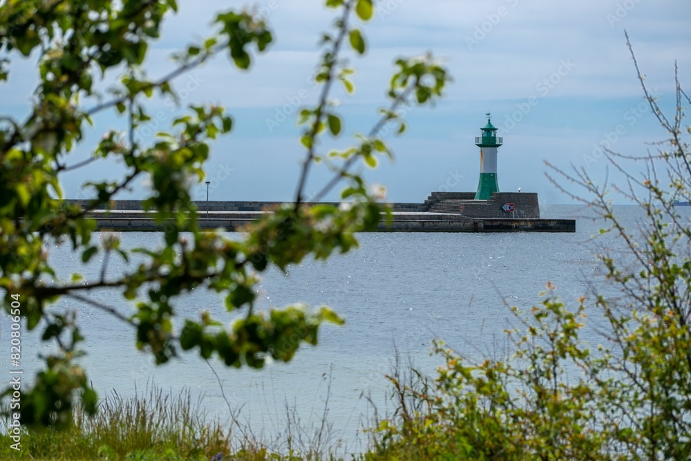 a green lighthouse sitting on top of a rocky shore near water a green lighthouse sitting on top of a rocky shore near water