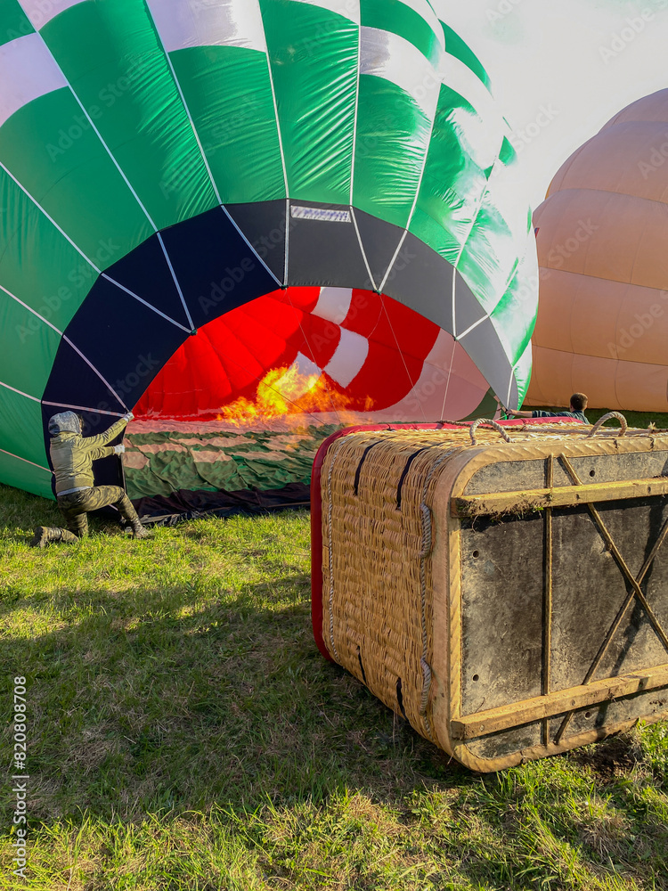 Obraz premium The process of inflating a balloon with fire. Basket hot air balloon. preparing for the flight with propane gas heat