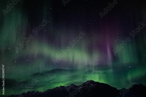 a green and purple auroral light shining in the sky