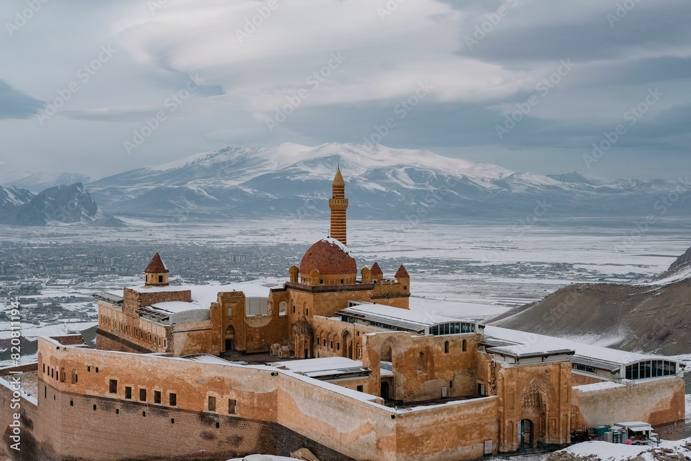 Naklejka premium Aerial view of Ishak Pasha Palace with snow-capped mountains in the background. Turkey.