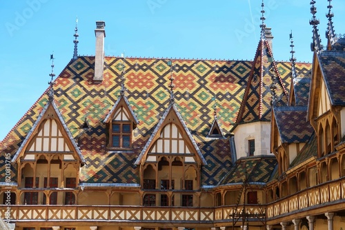 Toit en tuiles vernissées polychromes de Bourgogne, à motifs géométriques, à l’Hôtel-Dieu des Hospices Civils de Beaune, en Côte d’Or, avec des fenêtres en lucarne (France) photo