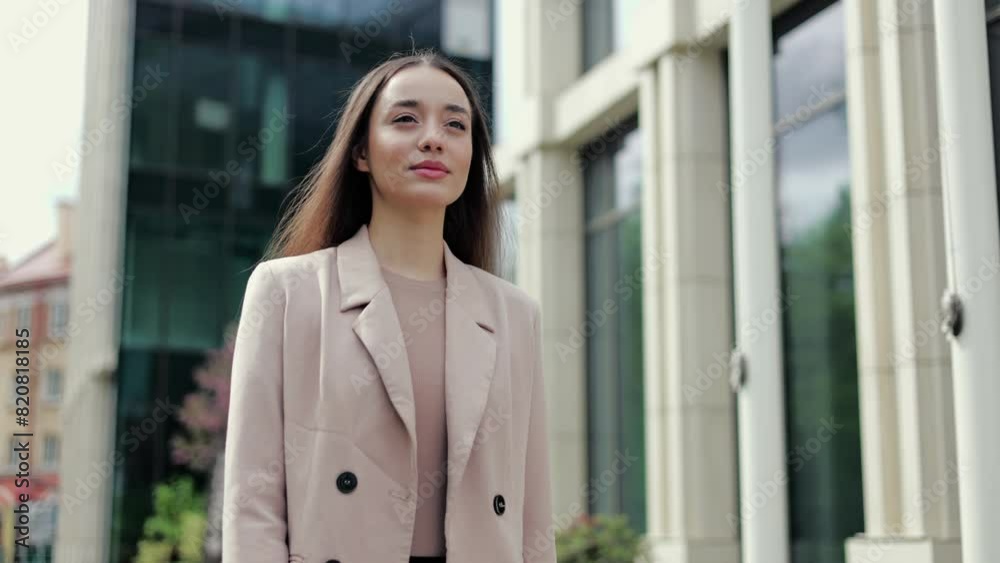 Low angle view of young entrepreneur passing by district with skyscrapers and looking forward confidently. Female director on her way to corporate building feeling ready starting new business day. Low angle view of young entrepreneur passing by district with skyscrapers and looking forward confidently. Female director on her way to corporate building feeling ready starting new business day.