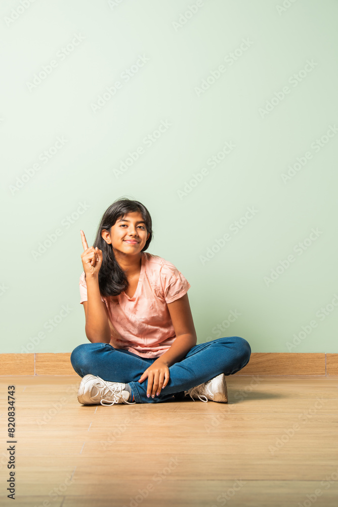 Asian Indian teenager girl child looking at camera while sitting on floor Asian Indian teenager girl child looking at camera while sitting on floor