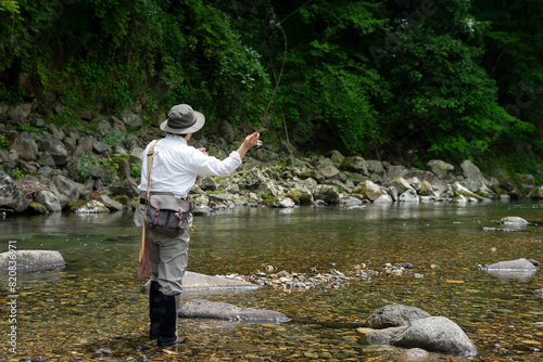 初夏の渓流で釣りをする男性