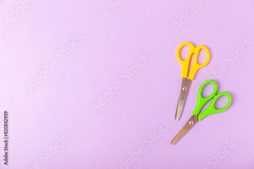 Bright children's scissors on a colored paper background. Stationery. Goods for school. Place for text. Copy space.Top view © Avocado_studio