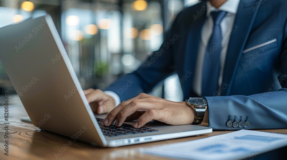 Businessman working diligently on a laptop in a cozy cafe environment with a focus on productivity and modern work culture Businessman working diligently on a laptop in a cozy cafe environment with a focus on productivity and modern work culture