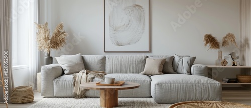 Simple living room with a grey sofa, a coffee table, and a single abstract artwork, minimal decor and neutral tones, open and airy photo
