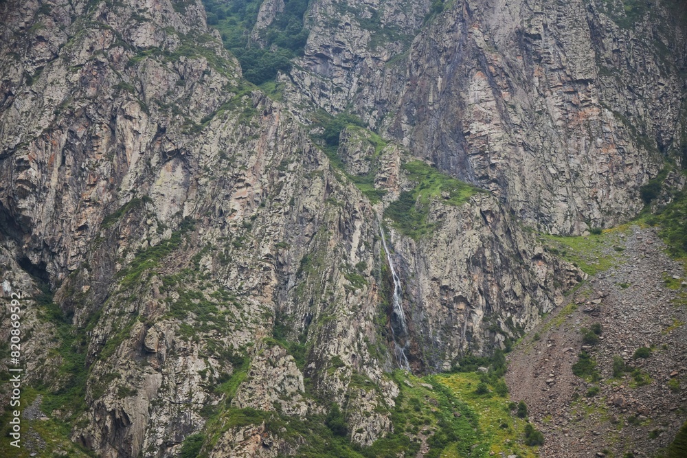 A waterfall among the high mountains. Natural landscape A waterfall among the high mountains. Natural landscape