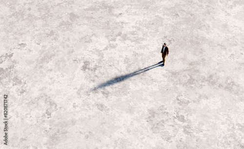 Man casting long shadow on empty ground