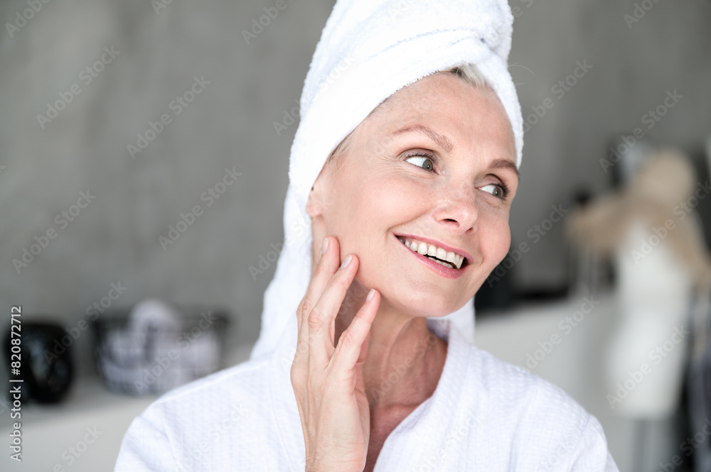Smiling mature woman standing in bathroom after taking shower Smiling mature woman standing in bathroom after taking shower