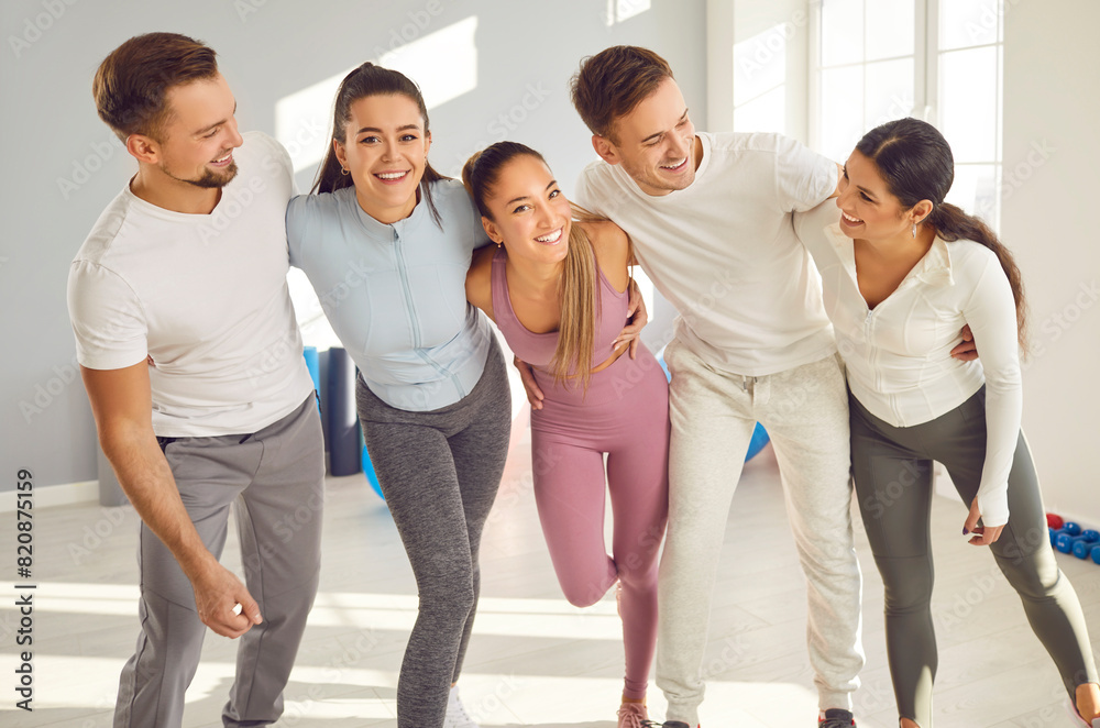 Obraz premium Group of athletes hugging looking into camera smiling and posing. Athletes embody spirit of teamwork and support bond shared among athletes Friendship teamwork mutual encouragement in sports