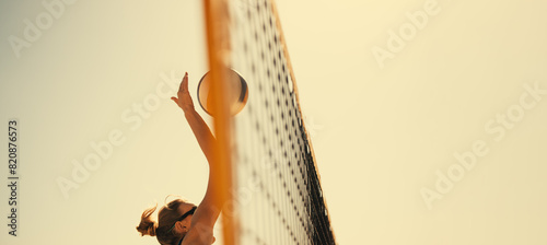 Pro athlete spiking ball in panoramic coastal game play at summer beach tournament photo