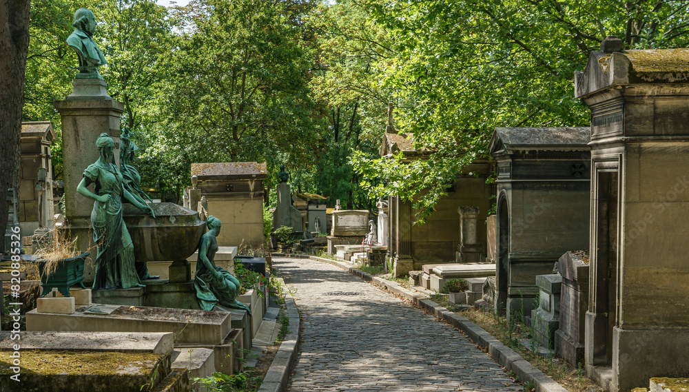 I walk among tombs in the Père-Lachaise cemetery in Paris, uncrowded and in summer.